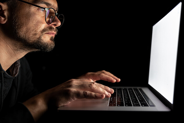 man-with-glasses-works-laptop-dark_1.jpg