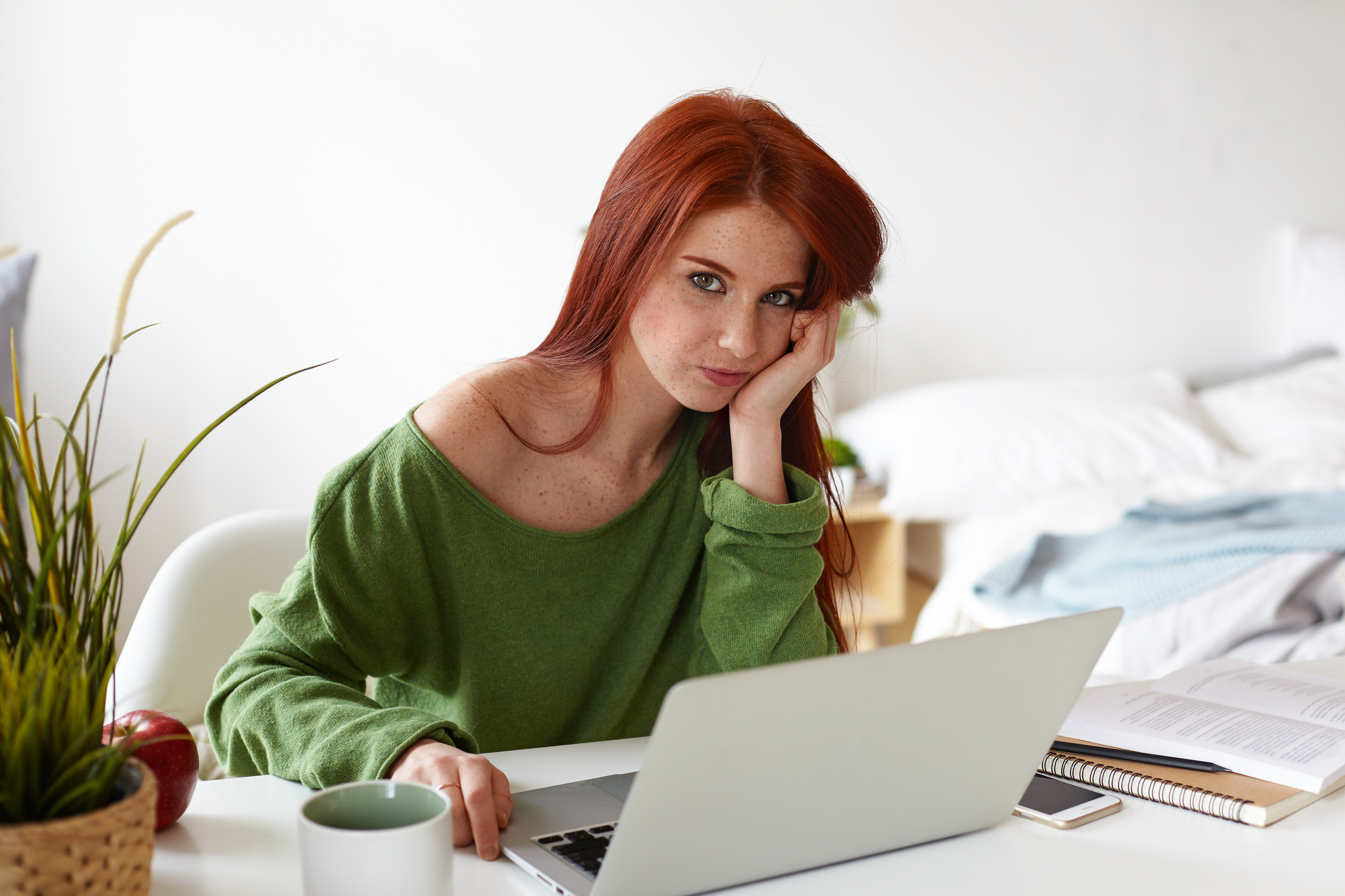 picture-beautiful-casually-dressed-european-student-girl-with-red-hair-having-bored-expression-while-doing-research-project-home-sitting-workplace-with-laptop-phone-textbooks-desk.jpg